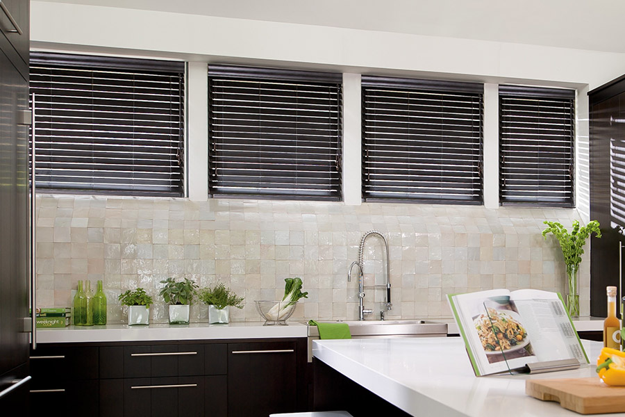Choose custom Polywood faux wood blinds for your kitchen in Bakersfield. Special shaped faux wood blinds in several windows above a sink.