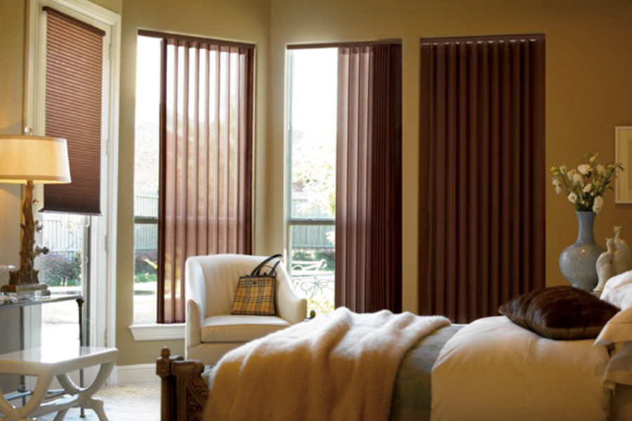 Choose durable and high-quality fabric or vinyl vertical blinds in Bakersfield. Maroon fabric vertical blinds inside a bedroom