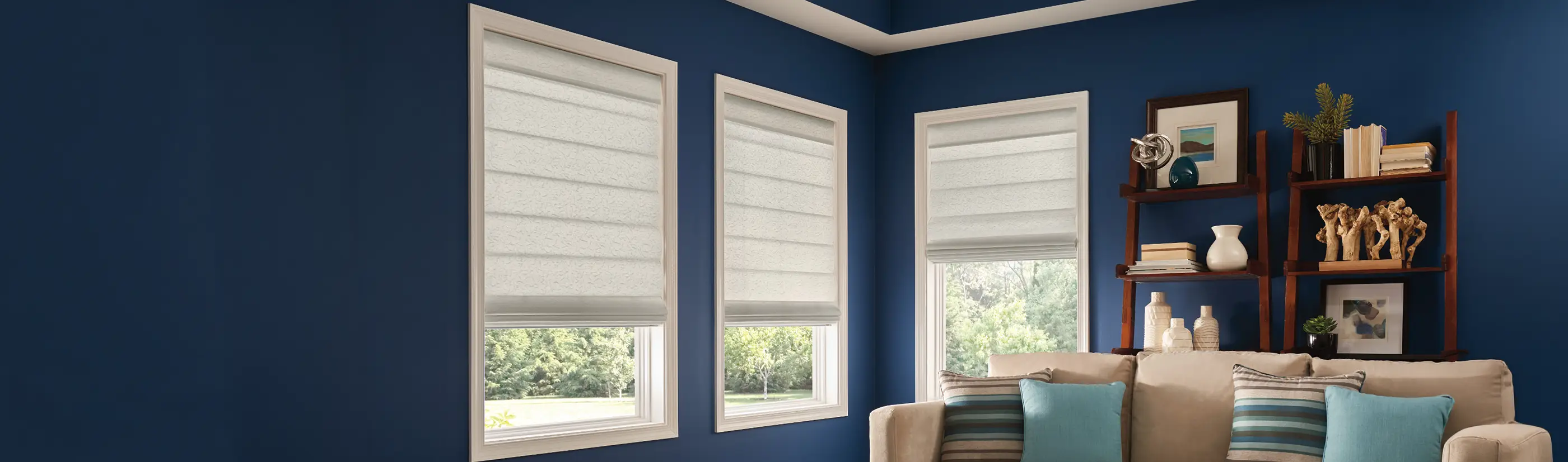 Gray roman shades in a navy blue wall living room area