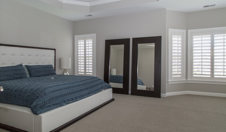 Polywood plantation shutters work well with minimalist design. White shutters in a minimalist bedroom in Bakersfield.