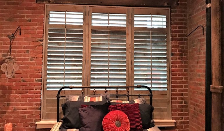 Reclaimed wood shutters provide an organic feel to your minimalist spaces. Reclaimed wood shutters surrounded by brick wall.