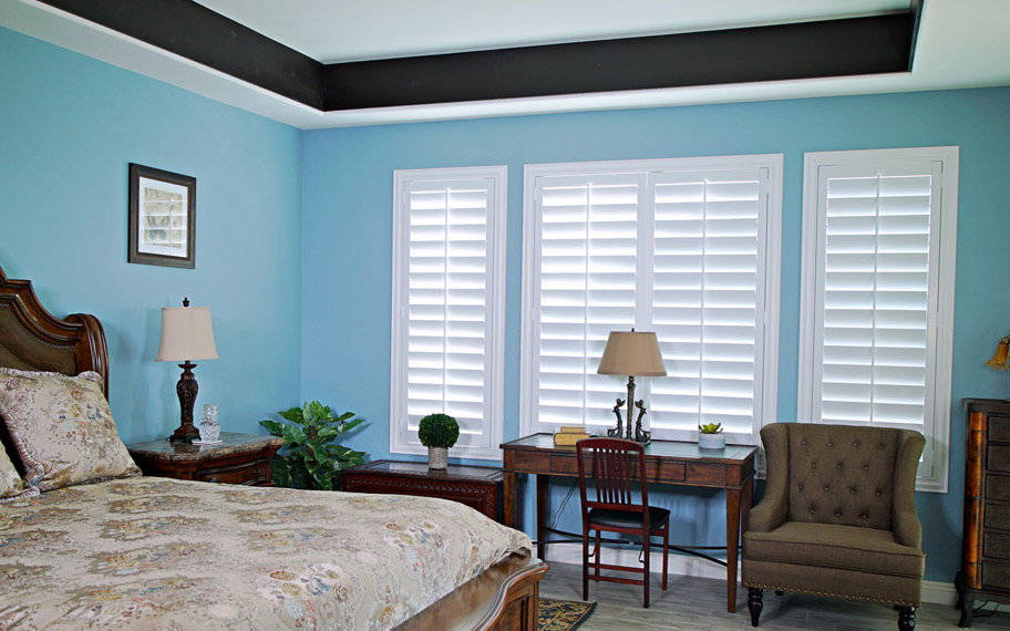Polywood shutters provide insulation for the perfect temperature all year long in Bakersfield. Polywood shutters in a bedroom.