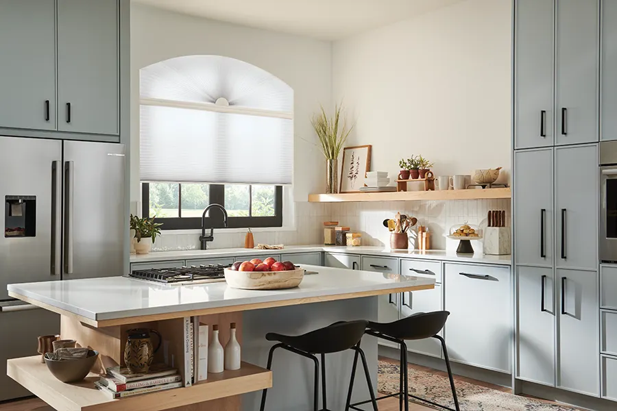 arched window above the kitchen sink with cellular shades in white