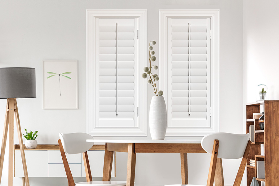 Sunburst's selection of stylish window treatments for designers in Bakersfield makes it easy to find the perfect ones for every design job.  White Polywood shutters on two windows in a modern Scandinavian-style room