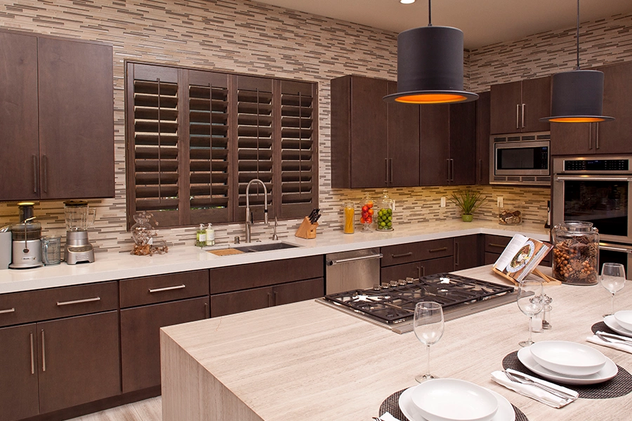 Dark wood Ovation shutters on a kitchen window with matching cabinetry