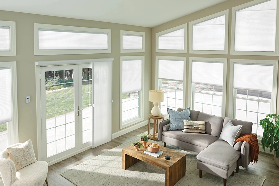 White sheer shades on living room windows of different sizes and shapes